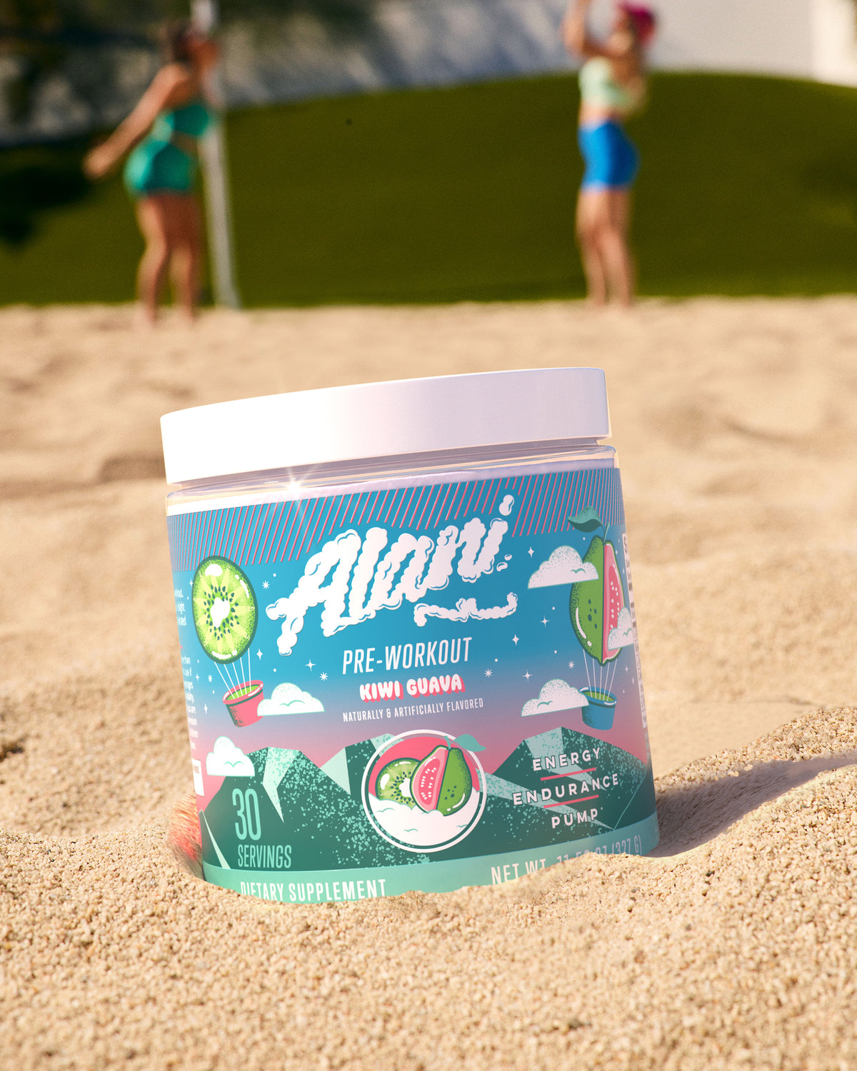 Pre-workout in Kiwi Guava flavor sitting in the sand on a beach.